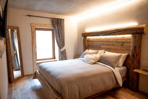 a bedroom with a large bed with a wooden headboard at Residenza dell'Aquila - appartamento in Vezza dʼOglio
