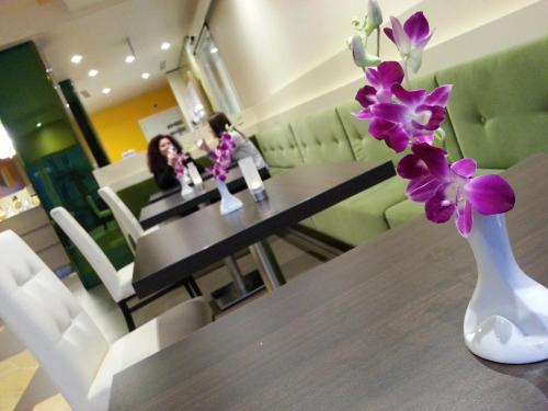 a vase with purple flowers sitting on a table at Palace Hotel & SPA La CONCHIGLIA D' ORO in Vicenza