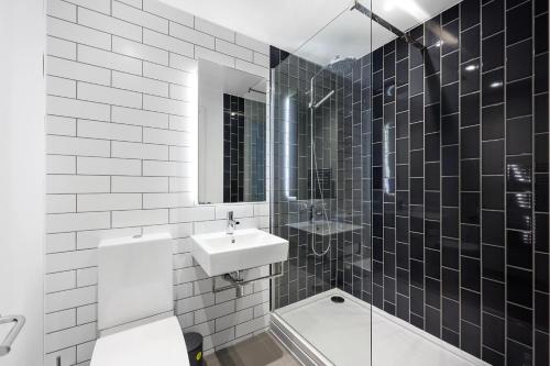 a bathroom with a sink and a toilet and a shower at Riverside View Apartments in London