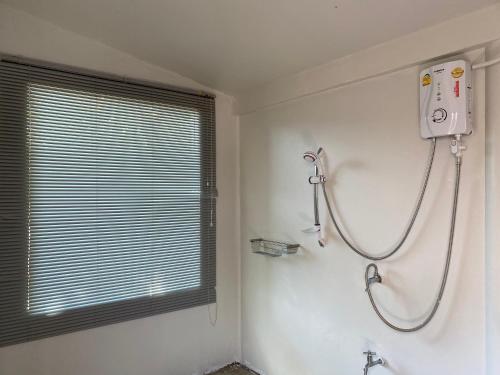 a shower in a white bathroom with a window at Royal mountain view Ratchaburi in Ratchaburi