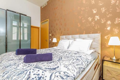 a bedroom with a large bed with purple pillows on it at Gozsdu Charming Suite by NeWave Apartments in Budapest