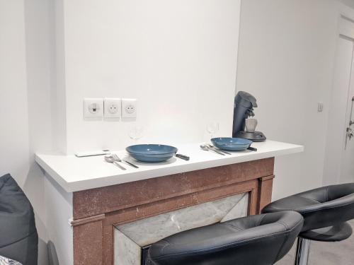 2 bols assis au-dessus d'une cheminée avec 2 chaises dans l'établissement Le Petit Nautin centre ville Saint-Etienne, à Saint-Étienne