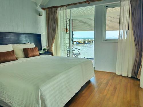 a bedroom with a bed and a view of the water at Satun Sea Balcony ระเบียงเล 