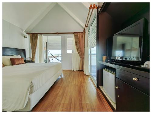 a bedroom with a large bed and a flat screen tv at Satun Sea Balcony in Ban Tanjong In