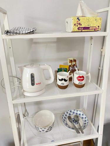 a white shelf with a tea kettle and dishes at Royal mountain view Ratchaburi in Ratchaburi