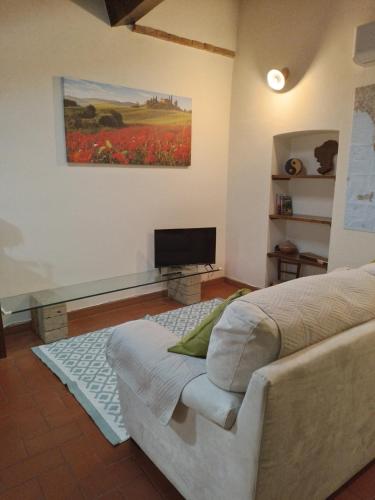 a bedroom with a bed and a television in it at Il Sole alla Terra in Terricciola