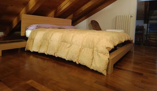 Cette chambre comprend un grand lit et du parquet. dans l'établissement Casa sul Cielo di Burano, à Burano