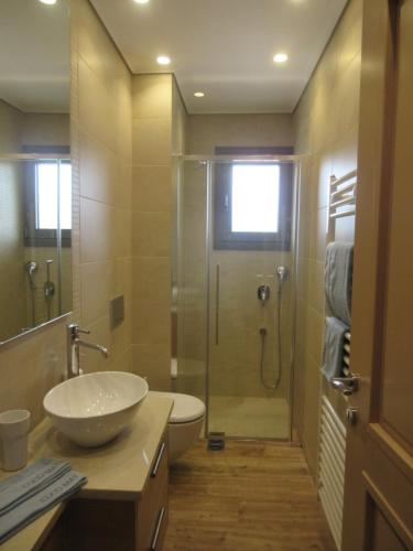 een badkamer met een douche, een wastafel en een toilet bij Seaside retreat house in Paralía Sergoúlas