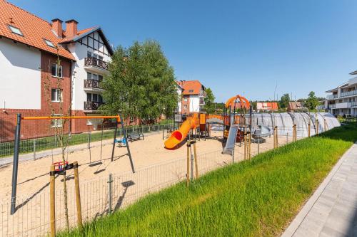 a park with a playground with a slide at Flatbook Apartamenty - Sztutowo Baltic Garden in Sztutowo