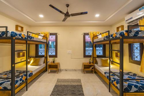 a room with three bunk beds and a ceiling fan at Zostel Visakhapatnam (Vizag) in Visakhapatnam