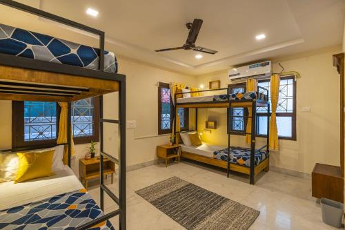 a bedroom with two bunk beds and a room with a bed at Zostel Visakhapatnam (Vizag) in Visakhapatnam