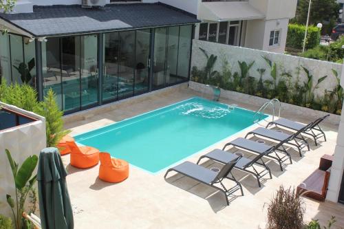 a swimming pool with chairs and a house at ECHINUS HOTELS in Lara