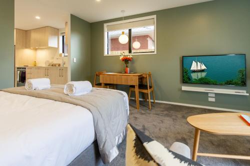 una camera con letto, TV e tavolo di Luxury Escape for 2, Single Level Studio, Papanui a Christchurch