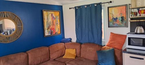 a living room with a brown couch and blue walls at Chez Nat in Rocbaron