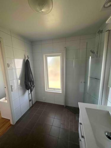 a bathroom with a shower and a sink and a refrigerator at Lilla Ridhuset in Löddeköpinge
