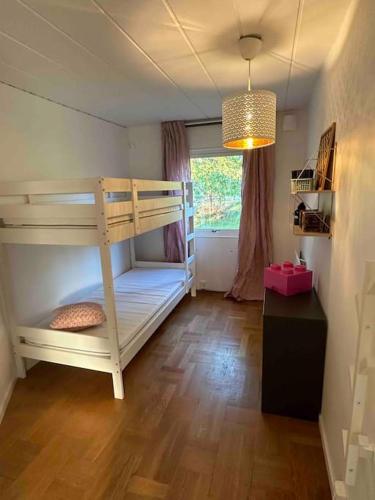 a bedroom with a bunk bed and a window at Lilla Ridhuset in Löddeköpinge