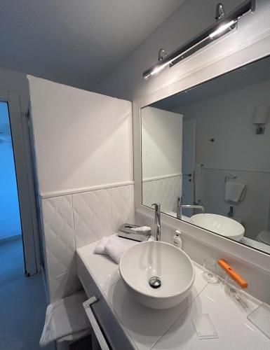 une salle de bain avec un lavabo et un grand miroir dans l'établissement CAMARU CANTU, à Bonifacio