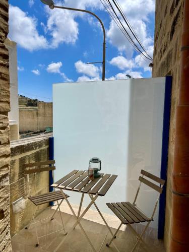 a table and two chairs sitting on a balcony at Ta Pinu Guesthouse in Għarb