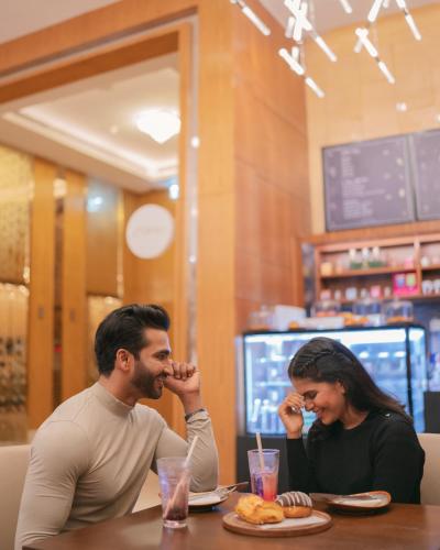 a man and woman sitting at a table in a restaurant at Courtyard by Marriott Navi Mumbai in Navi Mumbai