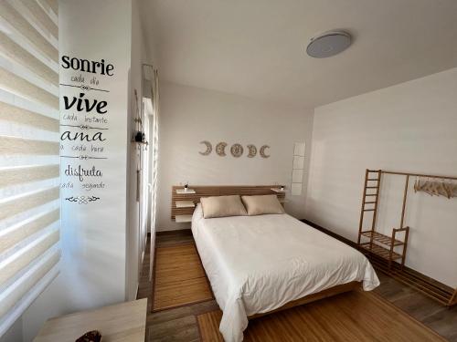 1 dormitorio con 1 cama y un cartel en la pared en Tanxil 44, en Rianjo