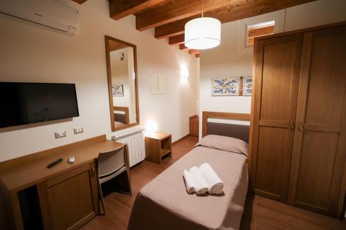 Dormitorio con cama, escritorio y TV en Camere U Campanaru, en Gratteri