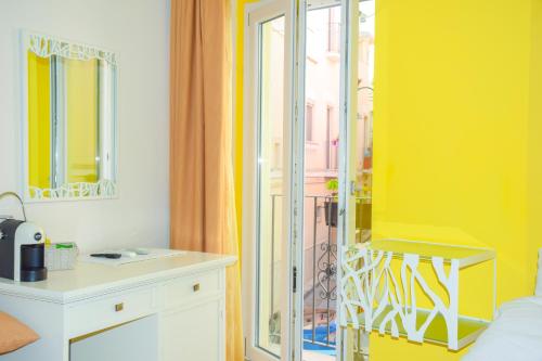 グラヴィーナ・イン・プーリアにあるB&B Santa Sofiaの黄色の壁と鏡が特徴のベッドルーム