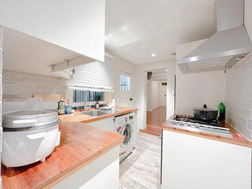 a white kitchen with a sink and a stove at Pyrnmont Terrace & Townhouse in Sydney