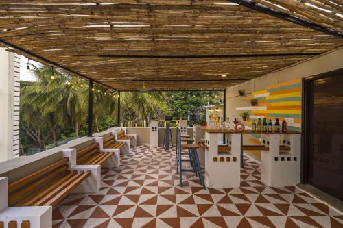 a restaurant with benches and a bar on a tiled floor at Zostel Visakhapatnam (Vizag) in Visakhapatnam