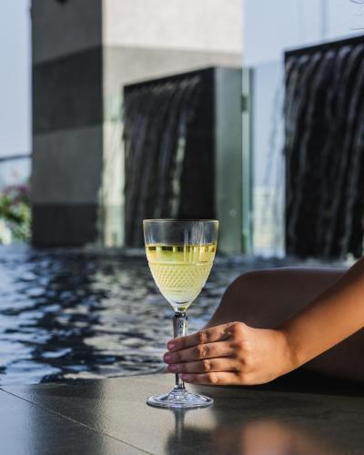 a woman holding a glass of wine on a table at Courtyard by Marriott Navi Mumbai in Navi Mumbai