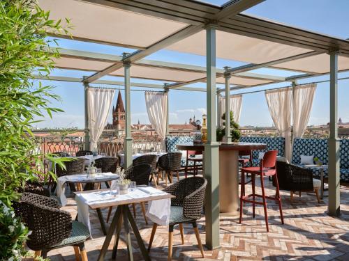 eine Terrasse in einem Restaurant mit Tischen und Stühlen in der Unterkunft Vista Palazzo in Verona