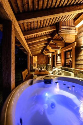 a large jacuzzi tub in a room with wooden ceilings at Wenzlhof in Zwiesel