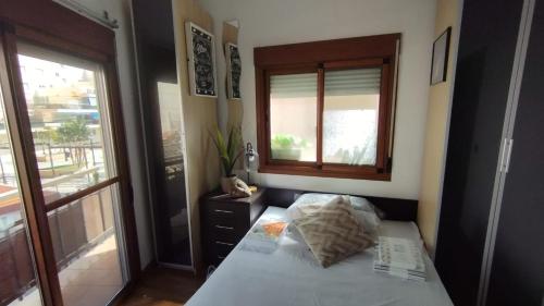 een kleine slaapkamer met een bed en een raam bij Piso playa centro fuengirola in Fuengirola