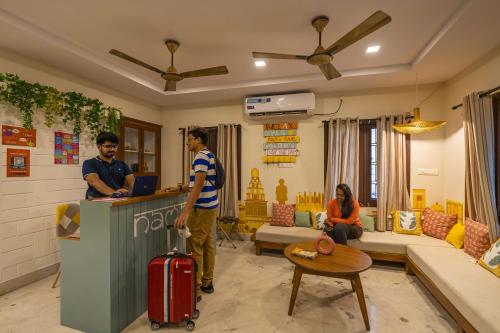 a man with a suitcase standing at a counter in a living room at Zostel Visakhapatnam (Vizag) in Visakhapatnam