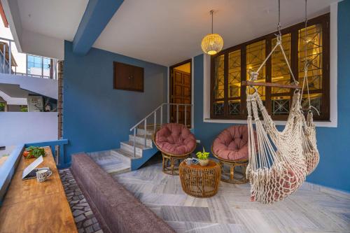 a room with a staircase with chairs and a hammock at Zostel Visakhapatnam (Vizag) in Visakhapatnam