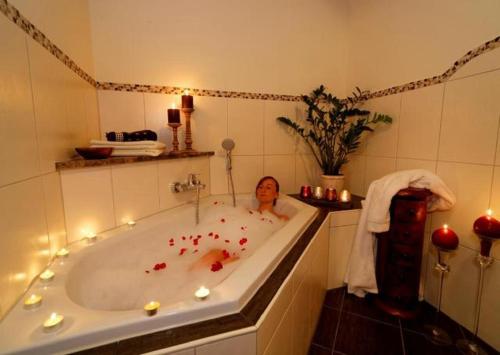 a woman in a bath tub with candles in it at Wenzlhof in Zwiesel