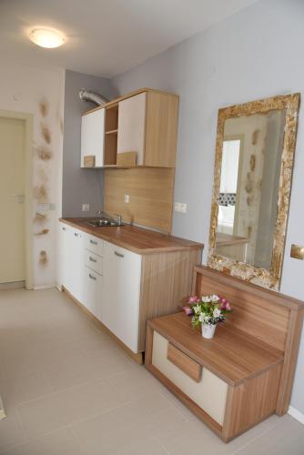 a kitchen with a sink and a counter with a mirror at Hotel Paradise Garden in Chernomorets