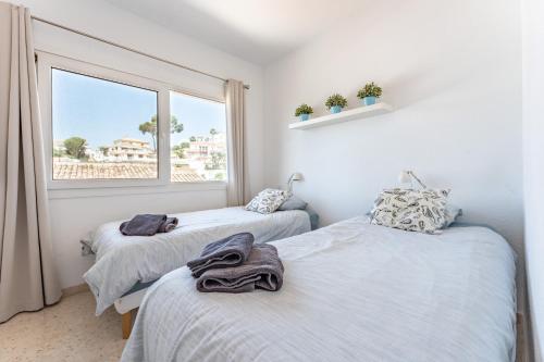 Dos camas individuales en una habitación con ventana. en Casa Leo holiday villa, en Mijas Costa