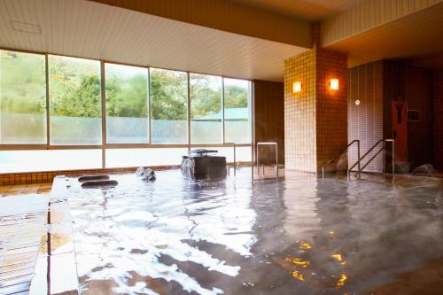 una piscina d'acqua in una stanza con finestre di Ooedo Onsen Monogatari Hotel Kinugawa Gyoen a Nikko