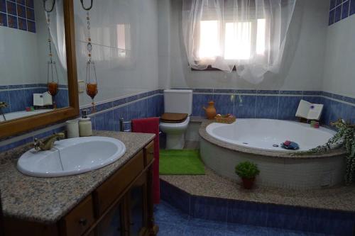 ein Badezimmer mit einer Badewanne, einem WC und einem Waschbecken in der Unterkunft Swimming pool, beach and garden in Nigran in Nigrán