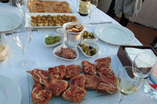 a white table with plates of food and glasses of wine at Swimming pool, beach and garden in Nigran in Nigrán