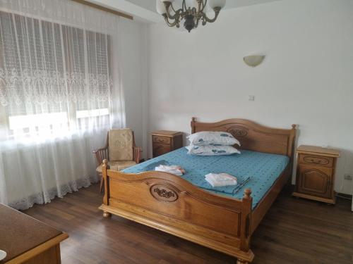 a bedroom with a wooden bed with blue sheets and a window at Vila Orizont in Venus