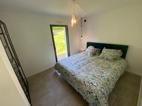 1 dormitorio con 1 cama con edredón en 2 Maisons de vacances Sittelles Lodge en Concarneau