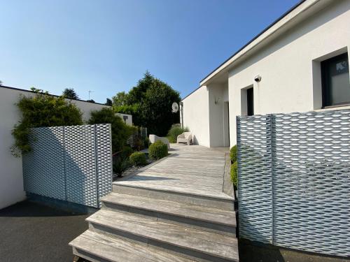 a wooden walkway next to a building with a fence at 2 Maisons de vacances Sittelles Lodge in Concarneau