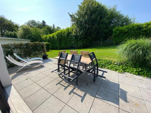 a patio with chairs and a table and a bench at 2 Maisons de vacances Sittelles Lodge in Concarneau