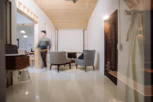 un hombre caminando por una habitación con sillas y una mesa en Spring Night, en Jeonju