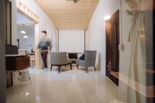 a man walking through a room with chairs and a table at Spring Night in Jeonju