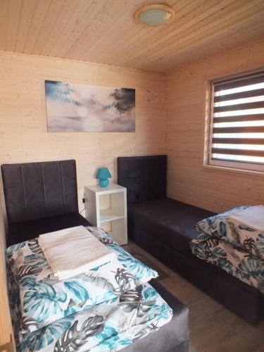 - une chambre avec 2 lits et un canapé dans l'établissement Domki letniskowe- Magnoliowa przystań, à Firlej