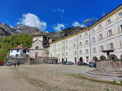 un gran edificio blanco con coches estacionados frente a él en Locanda del Santuario, en Campiglia Cervo