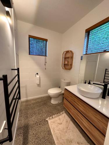 a bathroom with a sink and a toilet at West End private apartment in Ohope Beach