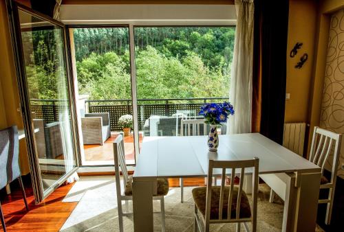 MendiondoにあるCasa con terraza para 4 personas en Plentziaのダイニングルーム(テーブル、椅子付)、大きな窓が備わります。